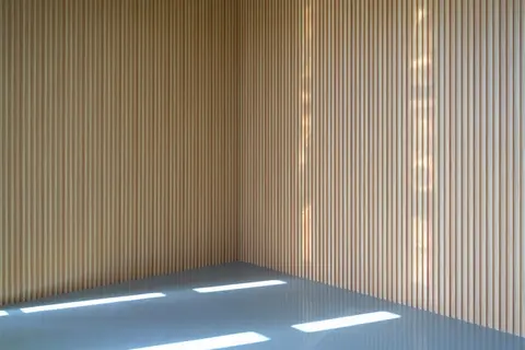 Leerer minimalistischer Raum mit warmem Licht und hellem Holz