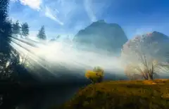 Sunlight breaks through mountain mist.