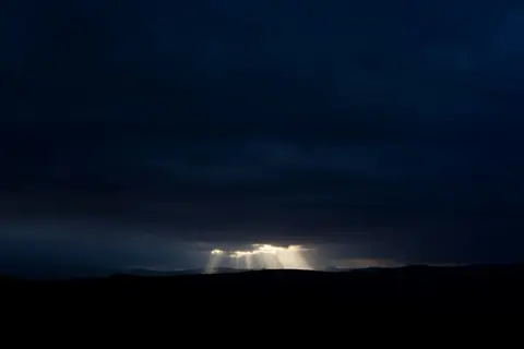 Distant light in a dark landscape.