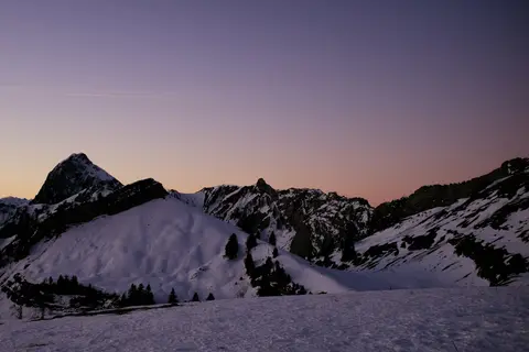 Verschneite Berggipfel in der Abenddämmerung