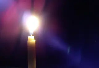 Kerzenlicht durchdringt violette Dunkelheit