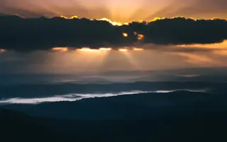 Sonnenaufgang über nebligen Bergketten