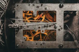 Zahnräder im Inneren einer antiken Uhr, dunkle Toene