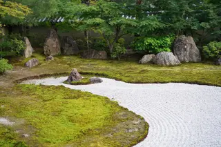 Japanischer Zen-Garten mit geharktem Kies, Moos und sorgfältig platzierten Steinen