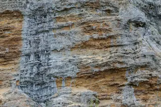Geschichtete Felsformationen mit sichtbaren Sedimentschichten in Braun und Grau