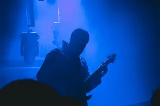 Silhouette eines Gitarristen im Gegenlicht, Dunkelheit und Musik