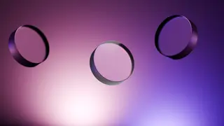 Drei runde optische Linsen schweben vor violettem Hintergrund