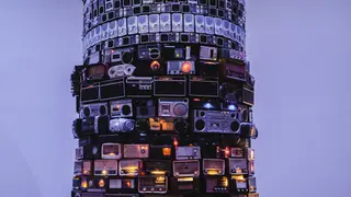 Hoher Sendeturm mit elektronischen Geräten, violett-blaue Toene