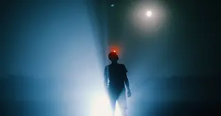 Silhouette eines Menschen im Mondlicht auf einem naechtlichen Feld