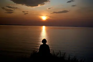 Sonnenaufgang ueber dem Baikalsee, goldenes Licht ueber stiller Wasserfläche